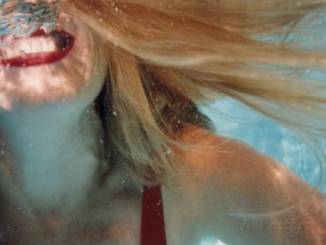 a-woman-with-red-lipstick-smiling-underwater